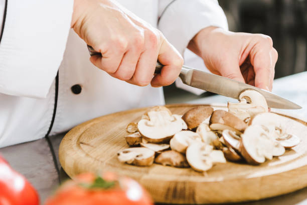 istock partial view of female chef cutting mushrooms in restaurant kitchen 1151155866
