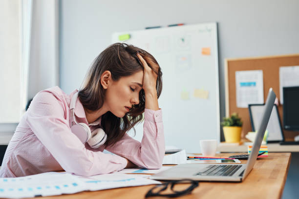 istock Tired young woman in office having headache working on project 1151156089