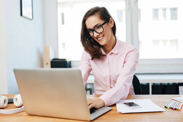 istock Happy young woman working using laptop in office 1151156468