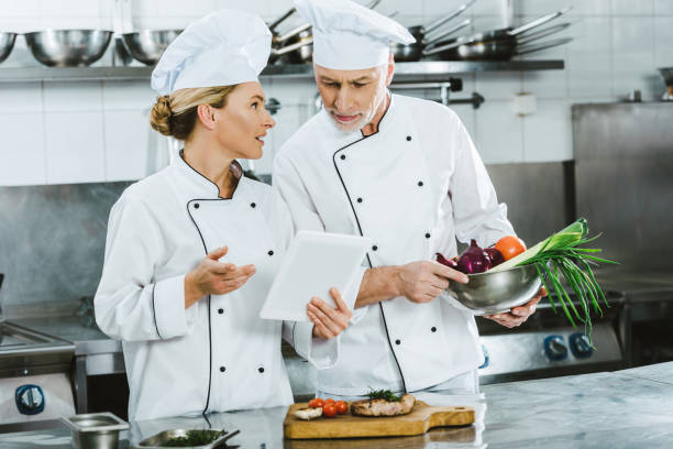 istock female and male chefs in iniforms using digital tablet during cooking in restaurant kitchen 1151157424