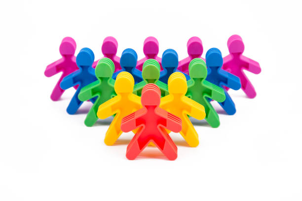 Toy people Isolated on white background. The red man stands apart from the group. Asociality, sociopathy. Rejected by society, lonely. Development of leadership and social qualities.