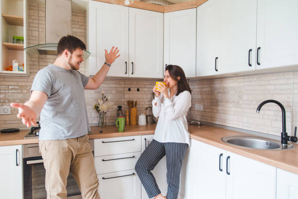 istock smiling man with woman at kitchen drinking tea 1151160139