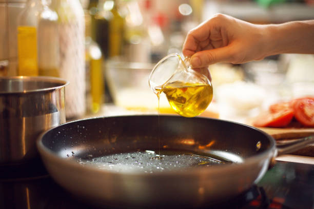 Cooking process. cook pours olive oil on a skillet Cooking process. cook pours olive oil on a skillet food state preparation shrimp prepared shrimp stock pictures, royalty-free photos & images