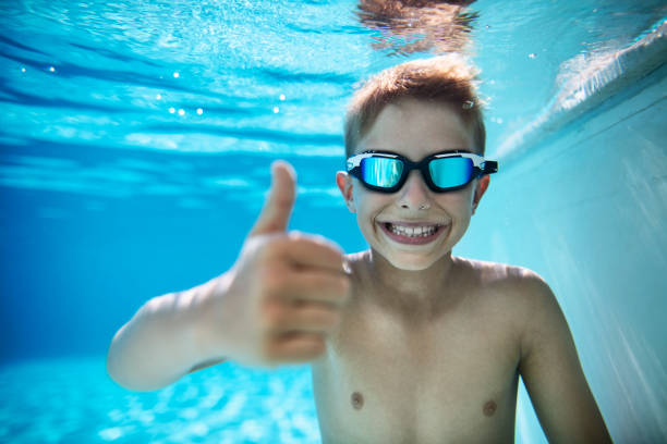 istock Little boy in pool showing thumbs up 1151160818