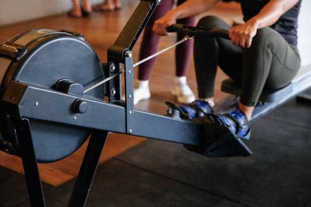 Close up women using a rowing machine