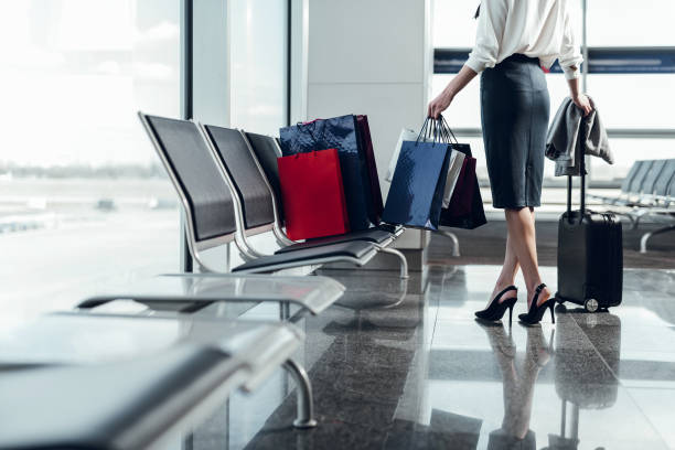 Slim woman is waiting for flight in lobby stock photo