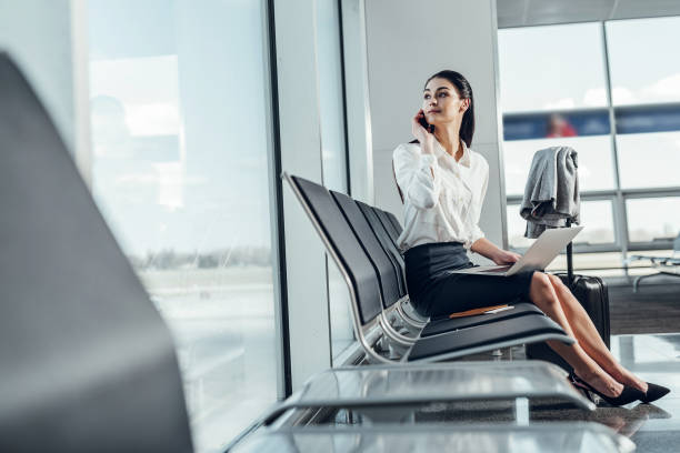 istock Serene woman is speaking on phone while waiting for flight 1151162031