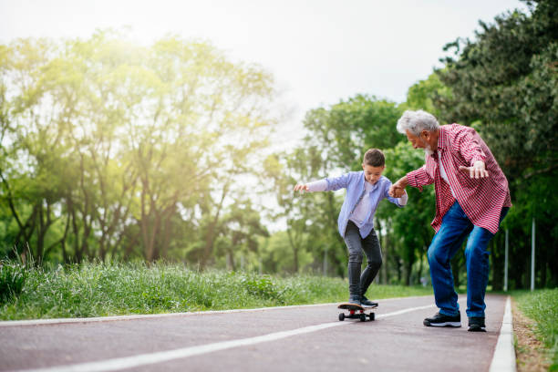 istock Grandfather and grandson trying skateboards 1151162049