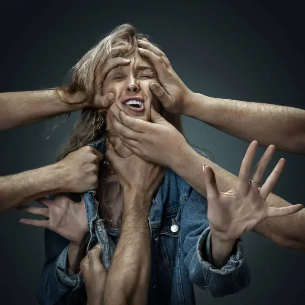 Photo of A young woman surrounded by hands like her own thoughts