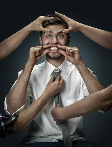 istock A young man surrounded by hands like his own thoughts 1151162582