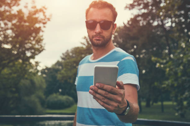 istock Trendy man using cellphone outdoors. 1151163291