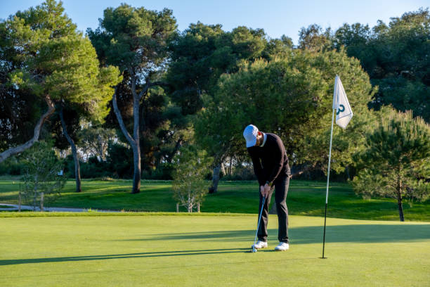 joueur de golf joue sur un terrain de golf - sports flag flag shadow golf flag photos et images de collection