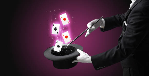 istock Magician making trick with wand and playing cards 1151163487