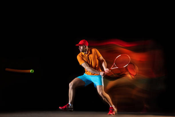 istock One caucasian man playing tennis on black background 1151165330