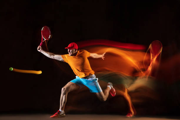 istock One caucasian man playing tennis on black background 1151165343