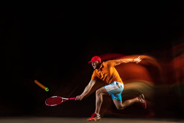 istock One caucasian man playing tennis on black background 1151165344
