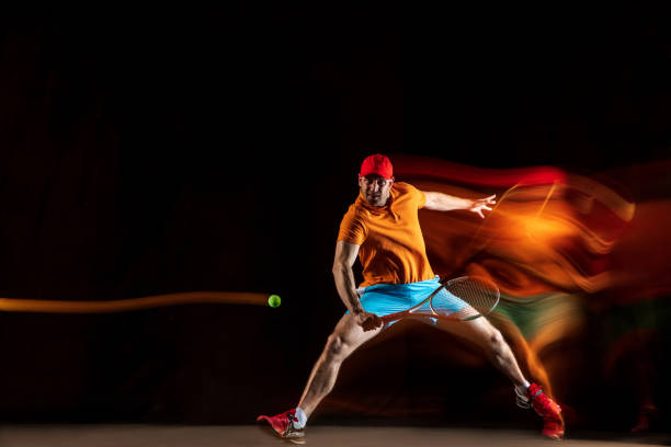 istock One caucasian man playing tennis on black background 1151165354