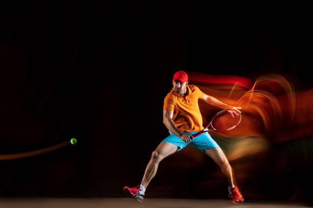 istock One caucasian man playing tennis on black background 1151165355