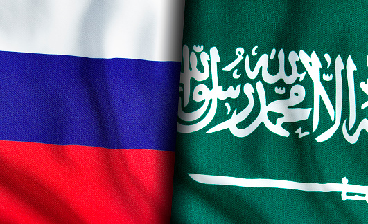 Russian and Saudi Arabian flags standing side by side