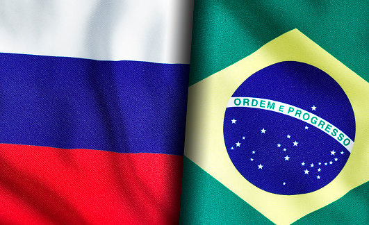 Russian and Brazilian flags standing side by side