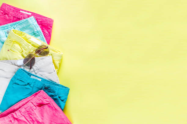 Summer sale shopping concept, Colorful background with various bright color children's women's clothes, glasses, sneakers, hat. Copy space flat lay, for banners, top view