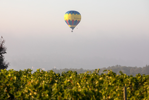 Saint Emilion, France - September 10, 2018: Air balloon flying in the morning over the vineyards near Saint Emilion. Gironde, France