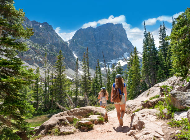 Friends hiking on summer vacation in Colorado mountains. Girls on summer vacation hiking trip in the mountains.People hiking on Emerald Lake Trail. Women exploring Colorado mountains. Estes Park, Rocky Mountains National Park, Colorado, USA. hallett peak stock pictures, royalty-free photos & images