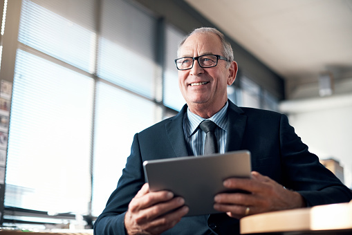 Shot of a mature businessman using a digital tablet in an office