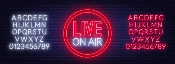 Live on air neon glowing sign on brick wall background. Template for design. Neon alphabet . Live on air glowing sign on brick wall background. Template for design. Neon alphabet . radio logo stock illustrations
