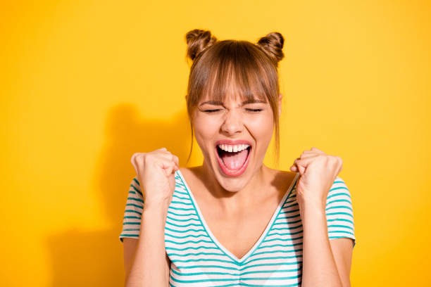 close up photo beautiful she her lady hold hands arms fists raised cheer yelling wild roar goal funny funky stylish hairstyle wear casual white striped t-shirt isolated yellow bright background - toothless grin imagens e fotografias de stock