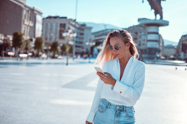 istock Elegant Female Browsing Social Media While Crossing Main Square 1151172288