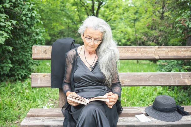 istock Senior woman sitting in park 1151172722