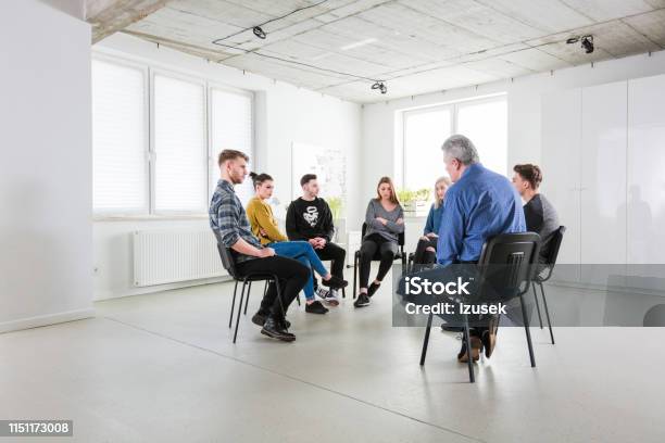 Young Students And Therapist Sitting In Meeting Stock Photo - Download Image Now - Group Therapy, Young Men, 18-19 Years