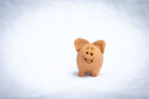 istock Cute little red clay pig doll on white texture background 1151175445