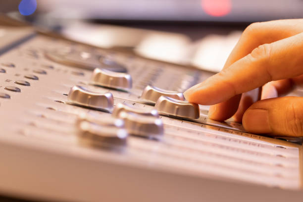 sound engineer fingers adjusting volume level fader on digital mixing console. music production, recording, broadcasting, music concept - human finger sound mixer music producer imagens e fotografias de stock