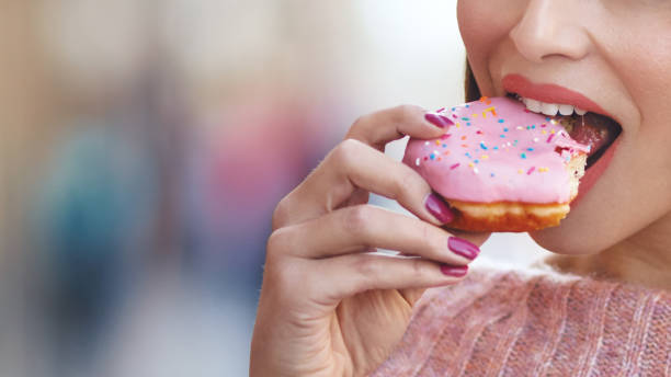 istock Unrecognizable young woman eating delicious donut. 1151176011