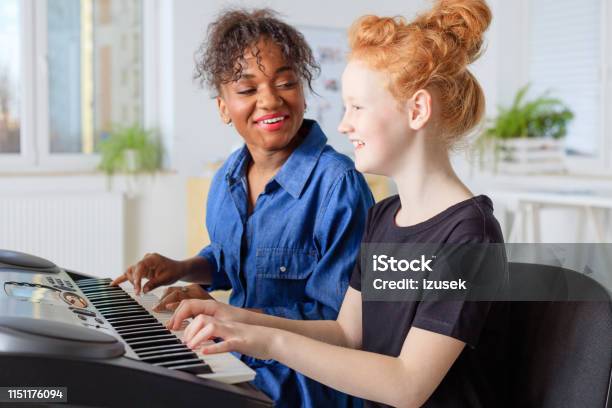 Instructor Singing While Teaching Piano In Class Stock Photo - Download Image Now - Two People, Keyboard Player, Music