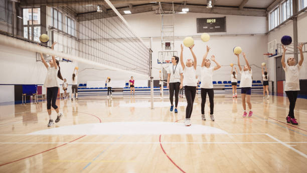 istock Female volleyball team exercising indoors 1151176611