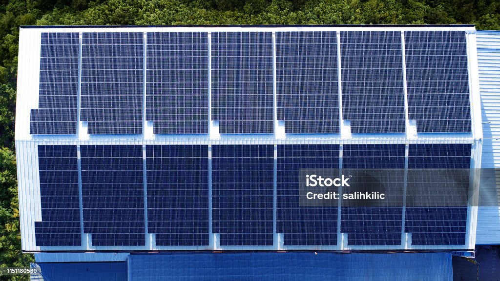 Commercial building factory rooftop installed photovoltaic solar panels A completed rooftop photovoltaic solar panelinstallation for a commercial factory Solar Energy Stock Photo