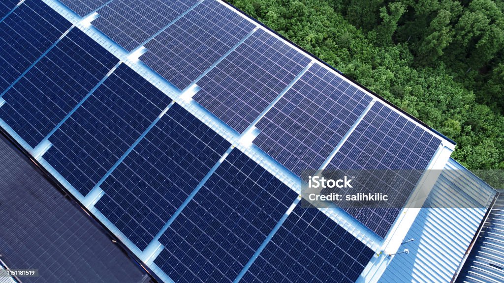Commercial building factory rooftop installed photovoltaic solar panels A completed rooftop photovoltaic solar panelinstallation for a commercial factory Solar Energy Stock Photo