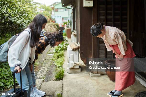 Landlady Greeting Female Guests Outside Ryokan Stock Photo - Download Image Now - Japan, Bowing, Japanese Ethnicity