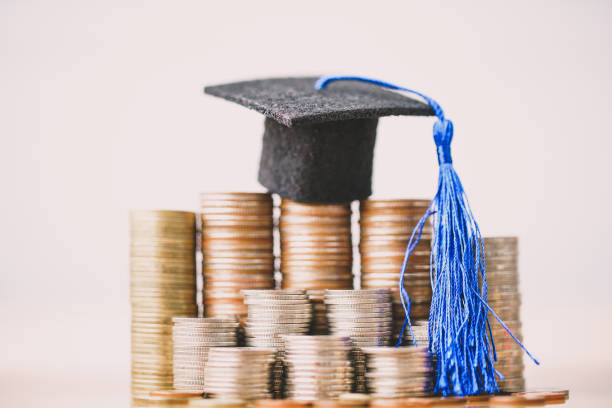 istock Graduation hat on coins money on white background. 1151187001
