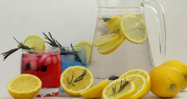 istock Cold drink with lemon, ice cubes and black currant in a jar glass 1151187096