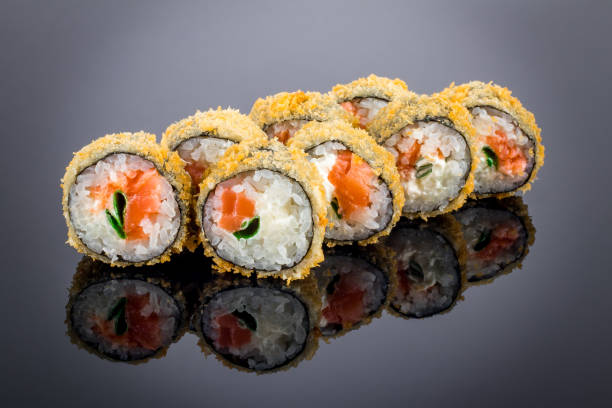 Hot roll with salmon tempura on black with reflection stock photo