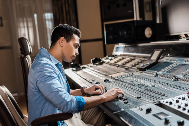 istock attentive mixed race sound producer working at mixing console in recording studio 1151191144