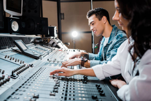 믹싱 콘솔에서 작업 하는 두 젊은 다문화 사운드 생산자 스튜디오 레코딩 - audio engineer 뉴스 사진 이미지