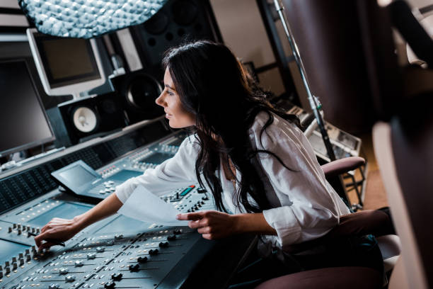 istock smiling sound producer working in recording studio at mixing console 1151191464