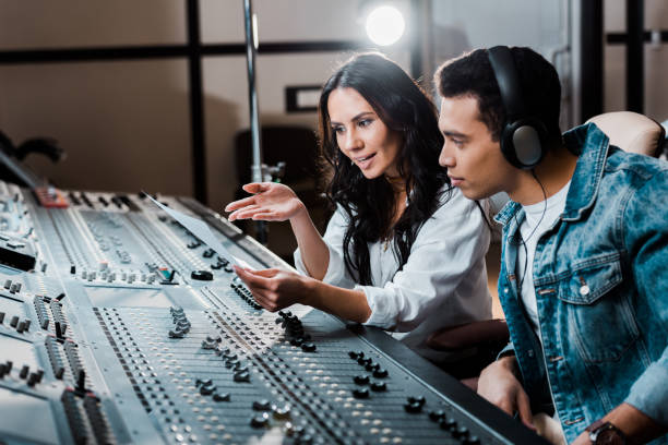 istock two young multicultural sound producers working at mixing console in recording studio 1151191486