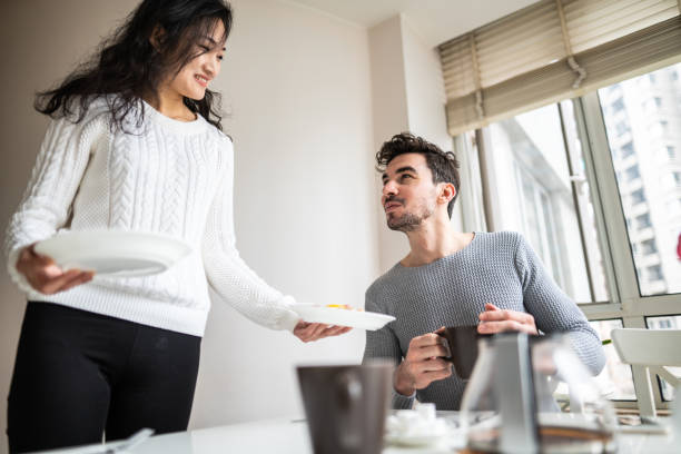 istock Low angle view of woman serving breakfast to man 1151192606