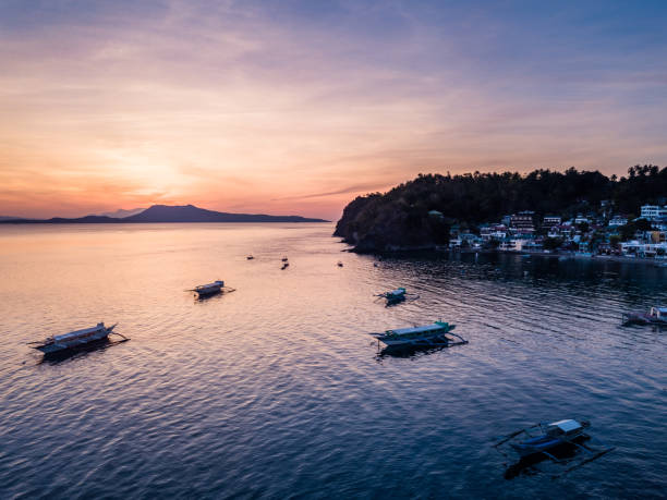 панорама воздушный дрон изображение восхода солнца и лодки в сабанг, пуэрто-галера, филиппины - sabang стоковые фото и изображения